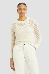 Sweater color crema con tejido crochet, cuello redondo y mangas largas.