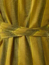 Vestido largo de lino y algodón con diseño de rayas verticales en tonos mostaza y verde. Presenta escote en V, cuello solapa ancho, mangas cortas con diseño capa, corte recto y lazo ajustable en la cintura.