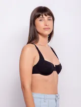 Top de bikini negro con textura de flores, corte media copa, breteles ajustables y gancho en la espalda.