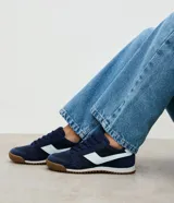 Championes estilo vintage runner color azul marino, con detalles laterales en color celeste claro y suela de goma dentada en tono marrón.
