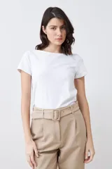 Remera de manga corta con escote bote, confeccionada en tejido liso de color blanco, con un corte ajustado y versátil.