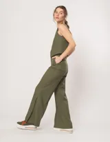 Pantalón negro de lino, tiro alto, corte palazo, con elástico en la pretina trasera, cierre delantero y broche interno. Tiene bolsillos laterales, dobladillo invisible y tajos a los costados.