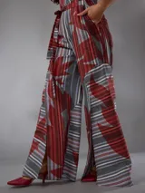 Mono de lino mezcla con estampado vegetal en tonos rojos, grises y blancos, de manga corta, escote en V y piernas amplias con cinto incorporado para ajustar la cintura.