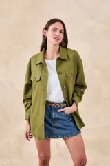 Sobrecamisa verde militar de lino y viscosa, corte oversize, con cuello camisero, cierre frontal con botones, mangas largas con puños abotonados, dos bolsillos de parche con solapa en el pecho y ruedo recto.