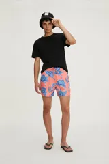 Short de baño color coral con estampado de flores azules y cordón ajustable en la cintura.