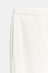Pantalón jogger de tiro alto y color azul marino, con cintura elástica ajustable mediante cordones con herretes metálicos y puños elásticos en los tobillos.