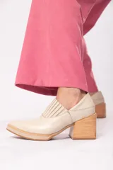 Zapato de cuero color beige con punta fina y taco de madera.
