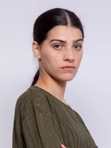 Remera blanca de corte amplio, cuello redondo y manga corta, con diseño de líneas verticales con transparencias.