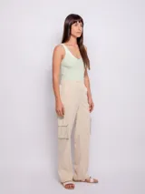 Pantalón cargo de tiro alto, color verde claro, con corte recto y ancho. Presenta bolsillos cargo laterales, costuras marcadas en el frente y elástico en la parte trasera de la cintura.