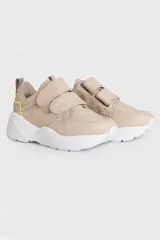 Zapatillas urbanas de cuero color beige con ajuste de velcro y suela blanca.