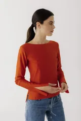 Remera de manga larga con cuello bote, confeccionada en tejido de algodón. Presenta un corte recto y aberturas laterales en los puños.