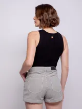 Short de tiro alto a rayas verticales en tonos beige y blanco, con cuatro bolsillos, cierre y botón metálico.