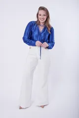 Pantalón palazo azul con detalle de cadena dorada en la cintura.