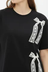 Remera oversize de algodón color gris oscuro, con cuello redondo, manga corta y estampado lateral de cadenas y llave en tonos claros.