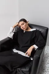 Sweater de punto liviano negro, con escote bote y mangas amplias de largo tres cuartos que aportan una silueta relajada y fluida.