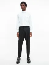 Camisa blanca de manga larga con cuello clásico y un bolsillo de parche en el pecho.