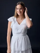Vestido blanco de gasa con capas, marca Julia Jordan. Escote en V, manga corta con volados, corte en cintura y abertura central en espalda con cierre invisible.