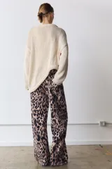 Jeans de tiro medio con diseño de cinco bolsillos, cierre frontal con cremallera y botón, y cintura con trabillas. Presenta un corte recto y largo completo con estampado animal print.
