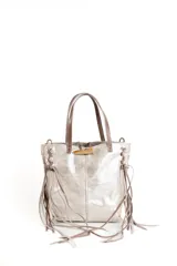 Cartera mini tipo tote color plateado con acabado metalizado, confeccionada en cuero. Presenta detalles de flecos laterales largos, manijas cortas en tono marrón y un cierre frontal con detalle de hueso decorativo.