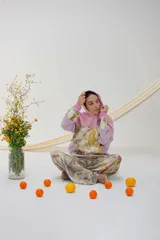 Canguro deportivo con capucha, color rosa y lila, con estampado de hojas y flores.