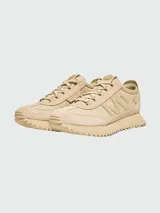 Zapatillas Moncler modelo Pacey 2, confeccionadas en una combinación de nobuk y tejido técnico en color beige. Presentan un diseño con suela dentada, cierre de cordones y el logo de la marca bordado en el lateral.