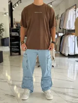 Remera oversize de manga corta color marrón con efecto gastado. Presenta inscripciones estampadas en color blanco en el frente y en la espalda.
