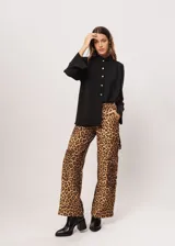 Camisa negra de cuello redondo con frunces y mangas largas con puños abiertos.