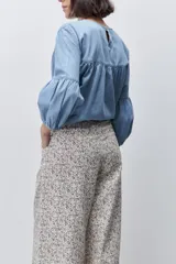 Pantalón de tiro alto con silueta amplia y piernas rectas, confeccionado en algodón con estampado floral. Cuenta con cierre frontal de botón y cremallera, y bolsillos laterales funcionales.