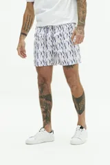 Short de baño con estampado geométrico en tonos azul y rosado, con cintura elástica y cordón de ajuste. Cuenta con bolsillos laterales y un bolsillo trasero.