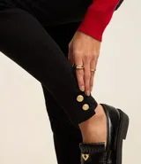 Pantalón skinny negro de sarga con elastano y cintura alta, con bolsillos delanteros y traseros.