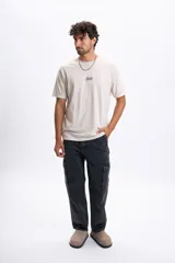 Pantalon de jean en color negro con efecto lavado, corte cargo con bolsillos laterales y diseño de costuras reforzadas en las rodillas.