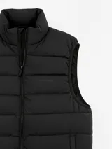 Chaleco acolchado de color azul marino, con cierre frontal completo y cuello alto. Presenta un diseño de costuras horizontales y logo bordado en el pecho.