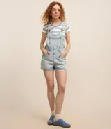 Peto corto de jeans marmorizado celeste, con tirantes ajustables, bolsillo tipo canguro y cierre lateral con botones.