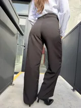 Pantalón sastrero de corte recto y tiro alto, color marrón oscuro con estampa de sutiles rayas diplomáticas blancas.