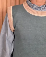 Chaleco tejido de punto color verde con detalles en tostado en el cuello redondo, sisas y dobladillo inferior.