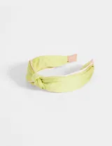 Vincha verde con nudo superior y borde rosado.