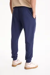 Pantalón de jogging negro sin friza, con puños elastizados en los tobillos y cordón ajustable en la cintura.