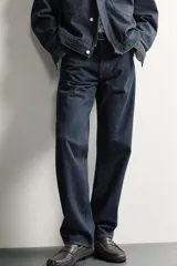 Pantalón jeans straight fit de tiro bajo, confeccionado en denim de algodón oscuro sin lavados, con diseño de pierna recta, cinco bolsillos y cierre frontal de botonadura.