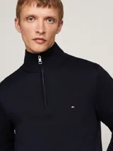 Sweater azul marino Tommy Hilfiger de punto liso, con cuello perkins, cierre de cremallera de un cuarto y logo bordado en el pecho.