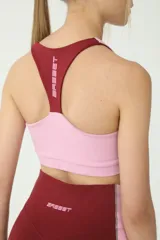 Top deportivo color borgoña con detalles en rosa y costuras en verde.