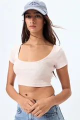 Top corto de color rosa claro, de corte ajustado y mangas cortas.