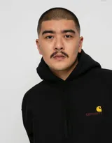 Buzo hoodie negro de Carhartt, modelo American Script, con logo bordado en color ocre en el pecho y bolsillo tipo canguro.