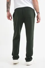 Pantalón deportivo verde inglés con cordón ajustable en la cintura y bolsillos laterales.