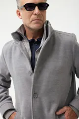 Gabán azul marino con cuello alto y pechera desmontable con cierre.