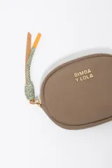 Monedero de forma ovalada marca Bimba y Lola, confeccionado en nylon color beige con detalles en verde oliva en el cierre y logo metálico dorado en el frente.