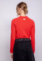 Polera gris de tejido de punto, cuello alto y mangas largas.