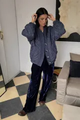 Campera acolchada color azul marino, con cuello en V, cierre frontal de botones y mangas abullonadas.