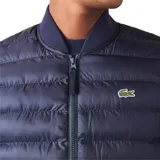Chaleco acolchado negro con cierre frontal y cuello alto. Logo de Lacoste bordado en el pecho.