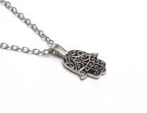 Collar plateado con dije de mano Hamsa con diseño calado.
