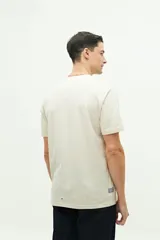 Remera color crema de manga corta con cuello redondo y estampado en el pecho.
